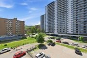 Hamilton apartment for rent - A parking lot with cars and apartment buildings in the background.