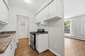 Hamilton apartment for rent - A kitchen with white cabinets and a black stove top oven.