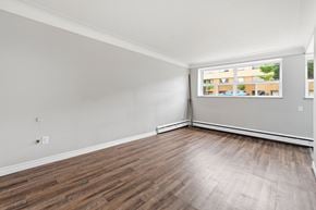 Hamilton apartment for rent - A room with wooden flooring and a window showing a view of a building.