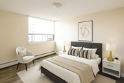 St. Catharines apartment for rent - A bedroom with a bed, chair, and lamp.