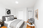 Hamilton apartment for rent - A bedroom with a bed, a chair, and a painting on the wall.