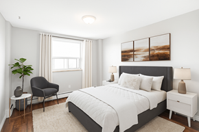 Hamilton apartment for rent - A bedroom with a large bed, a chair, and a painting on the wall.
