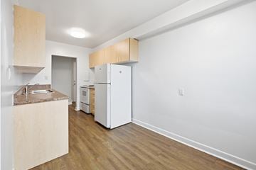 Hamilton apartment for rent - A kitchen with a white fridge and a white oven.
