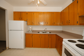 Hamilton apartment for rent - A kitchen with white appliances and wooden cabinets.