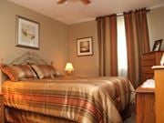 Hamilton apartment for rent - A bedroom with a bed, nightstand, and pictures on the wall.