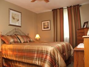 Hamilton apartment for rent - A bedroom with a bed, nightstand, and pictures on the wall.