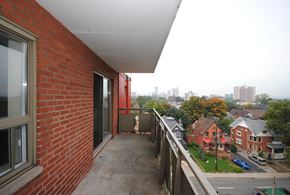 Hamilton apartment for rent - A balcony with a brick wall and a view of a residential area.
