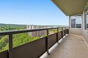 Hamilton apartment for rent - A balcony with a view of a cityscape and greenery.