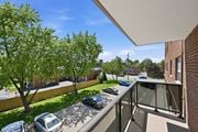 Hamilton apartment for rent - A balcony overlooks a parking lot and a tree-lined street.