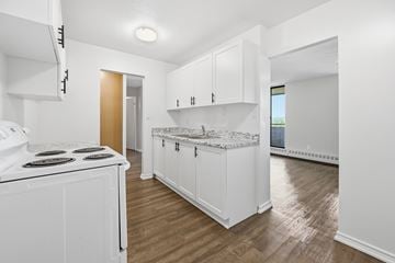 Hamilton apartment for rent - A kitchen with white cabinets and a white stove top oven.