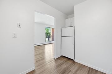 Hamilton apartment for rent - A white kitchen with a window and a wooden floor.