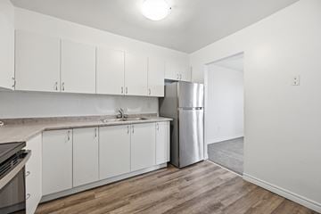 Hamilton apartment for rent - A kitchen with white cabinets and a stainless steel refrigerator.