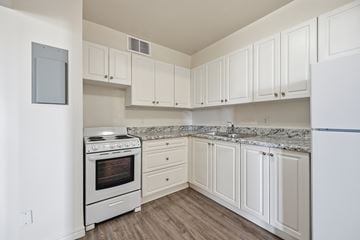 Hamilton apartment for rent - A white kitchen with a stove and cabinets.