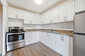 Hamilton apartment for rent - A kitchen with white cabinets and a granite countertop.