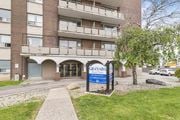 Hamilton apartment for rent - The entrance to a building named Granada with a blue sign in front.