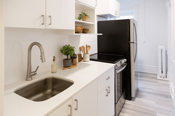 Kitchener apartment for rent - A modern kitchen with a black refrigerator and white cabinets.
