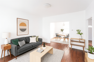 Cambridge apartment for rent - A living room with a grey couch, a coffee table, a dining table, and a painting on the wall.