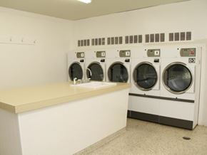 Hamilton apartment for rent - A laundromat with a row of washers and dryers.