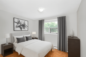 Burlington apartment for rent - A bedroom with a large bed, a nightstand with a lamp, and a framed picture on the wall.