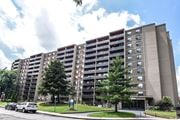 Hamilton apartment for rent - A large apartment building with a parking lot in front.