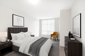 Woodstock apartment for rent - A bedroom with a bed, chair, and two framed pictures on the wall.