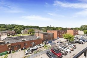 Stoney Creek apartment for rent - A parking lot with cars and a building in the background.