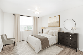 Hamilton apartment for rent - A bedroom with a large bed, a chair, and a painting on the wall.