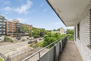 Hamilton apartment for rent - A view from a balcony looking down at a parking lot and buildings.