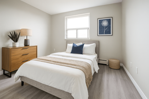 Hamilton apartment for rent - A bedroom with a bed, nightstand, and window.