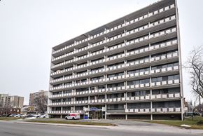 Hamilton apartment for rent - A large grey building with many windows and balconies.