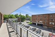 Hamilton apartment for rent - A parking lot with cars and a building in the background.