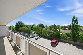 Hamilton apartment for rent - A parking lot with cars and a red car in the foreground.