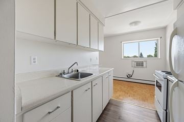Hamilton apartment for rent - A kitchen with white cabinets and a window.