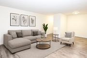 Kitchener apartment for rent - A living room with a grey sofa, a coffee table, a chair, and three framed pictures on the wall.