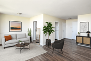 St. Catharines apartment for rent - A living room with a white couch, a coffee table, a chair, and a potted plant.