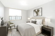Hamilton apartment for rent - A bedroom with a large bed, a chair, and a window.