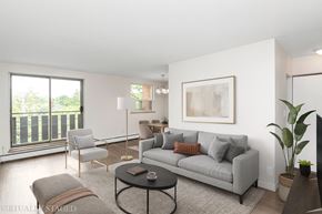 Hamilton apartment for rent - A living room with a grey couch, a coffee table, and a large window.
