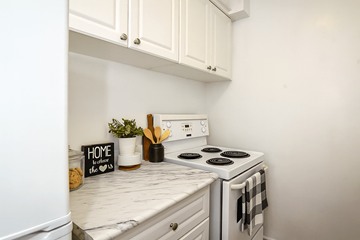 Hamilton apartment for rent - A white kitchen with a stove and a sign that says "home is where the heart is".