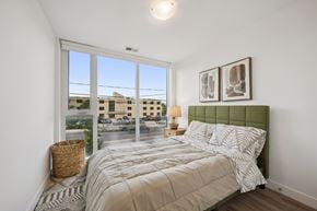 Kitchener apartment for rent - Bedroom with large windows and green upholstered headboard at The Maverick Apartments, Ontario, N2H 0E3