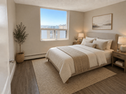 Hamilton apartment for rent - A bedroom with a large bed and a view of the city through the window.