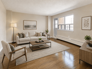Hamilton apartment for rent - A living room with a grey couch, a chair, a coffee table, and a plant.