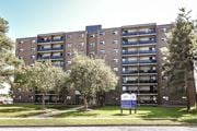 Kitchener apartment for rent - A large brick building with a blue sign in front of it.