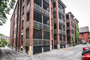 Hamilton apartment for rent - A red brick building with a black gate in front.