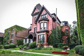 Hamilton apartment for rent - A red brick house with a black roof and ivy growing on it.