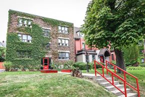 Hamilton apartment for rent - A red staircase leads up to a building with a red door.