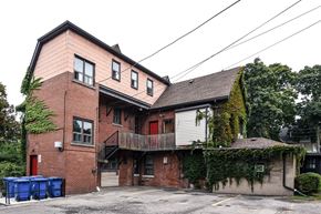Hamilton apartment for rent - A two-story building with a red door and a balcony.