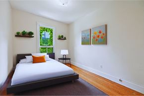 Hamilton apartment for rent - A bedroom with a bed, a window, and two paintings on the wall.