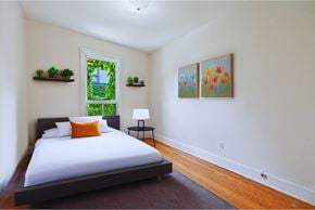 Hamilton apartment for rent - A bedroom with a bed, a window, and two paintings on the wall.