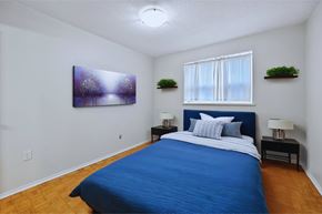 Hamilton apartment for rent - A bedroom with a blue bed and a painting on the wall.