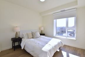 Hamilton apartment for rent - A bedroom with a large bed and two lamps on side tables at Roxy Apartments, Ontario